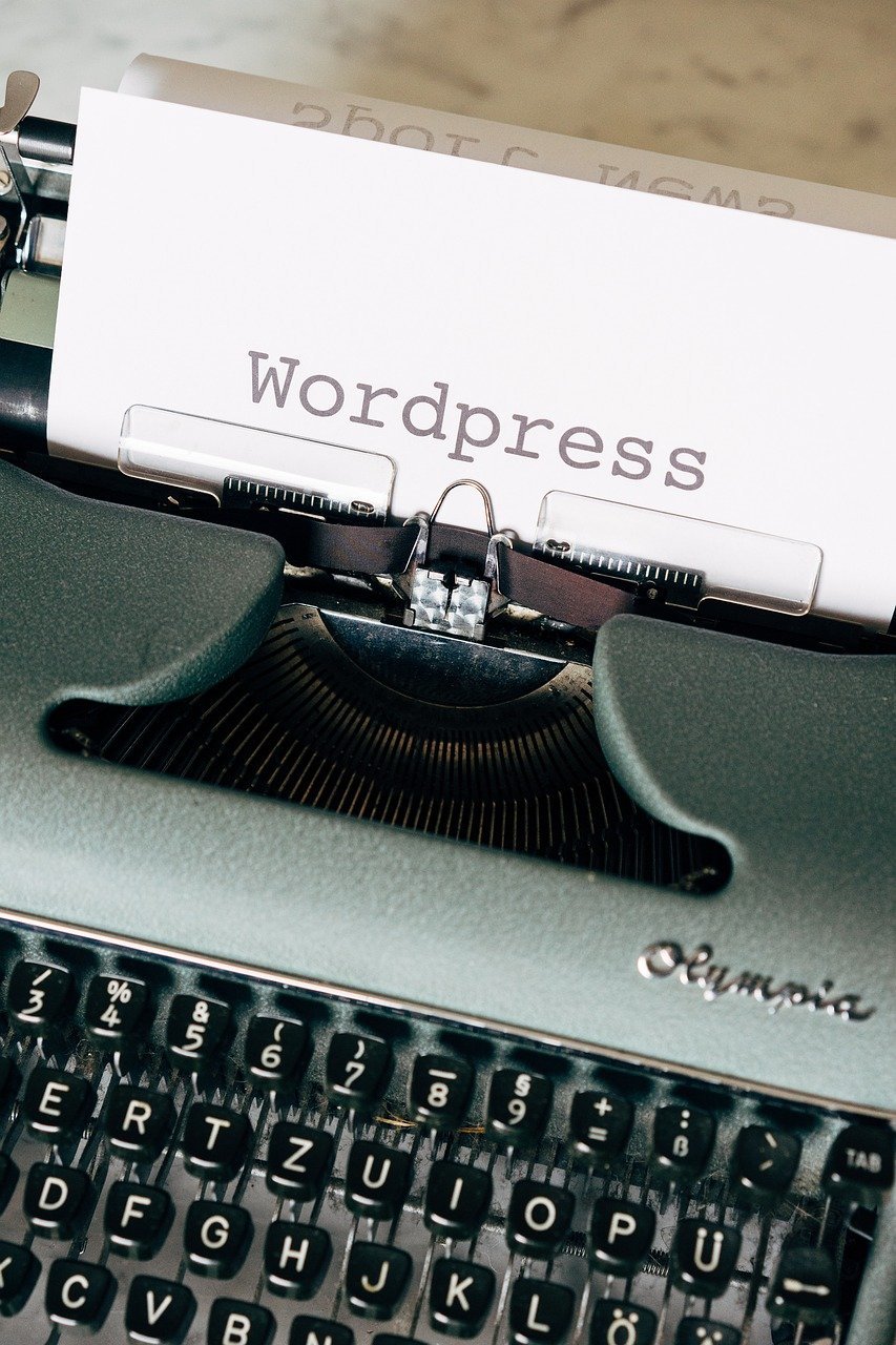 Schreibmaschine mit einem Blatt Papier, auf das das Wort „WordPress“ getippt ist